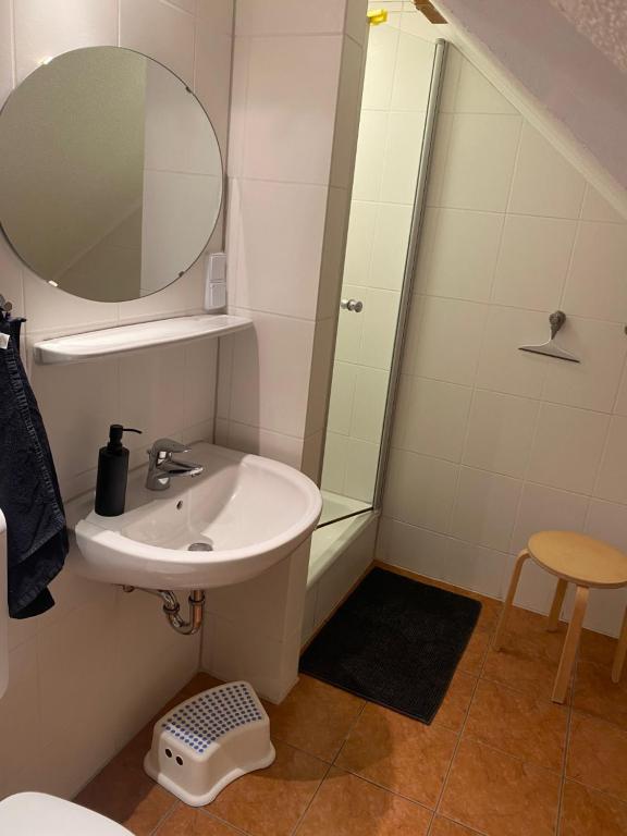 Badezimmer mit Waschbecken und rundem Spiegel